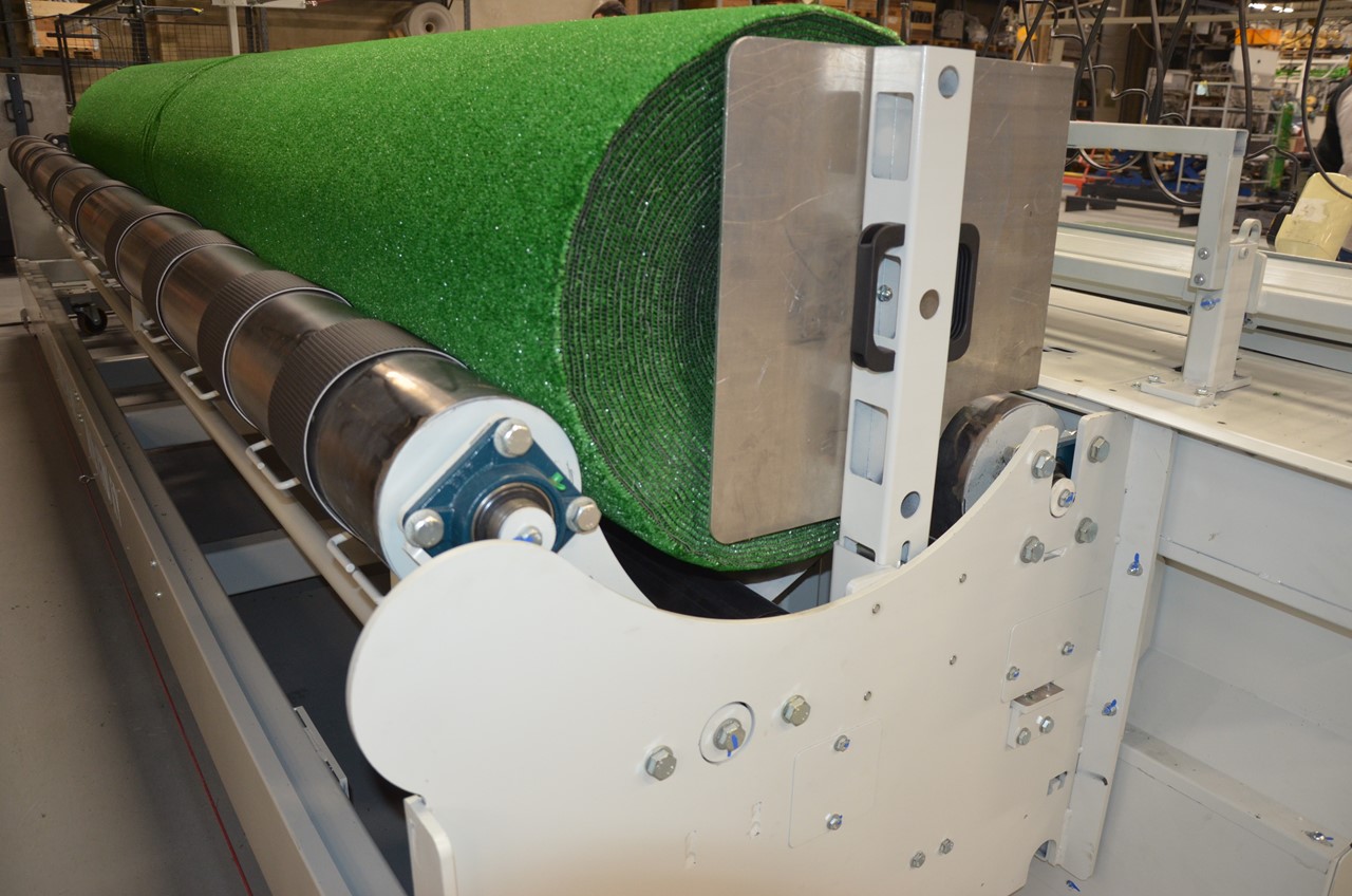 Unrolling cradle at coupon machine for artificial grass