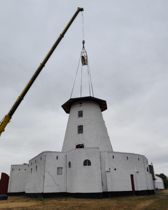 The historic windmill head is removed and a temperary seal is put on